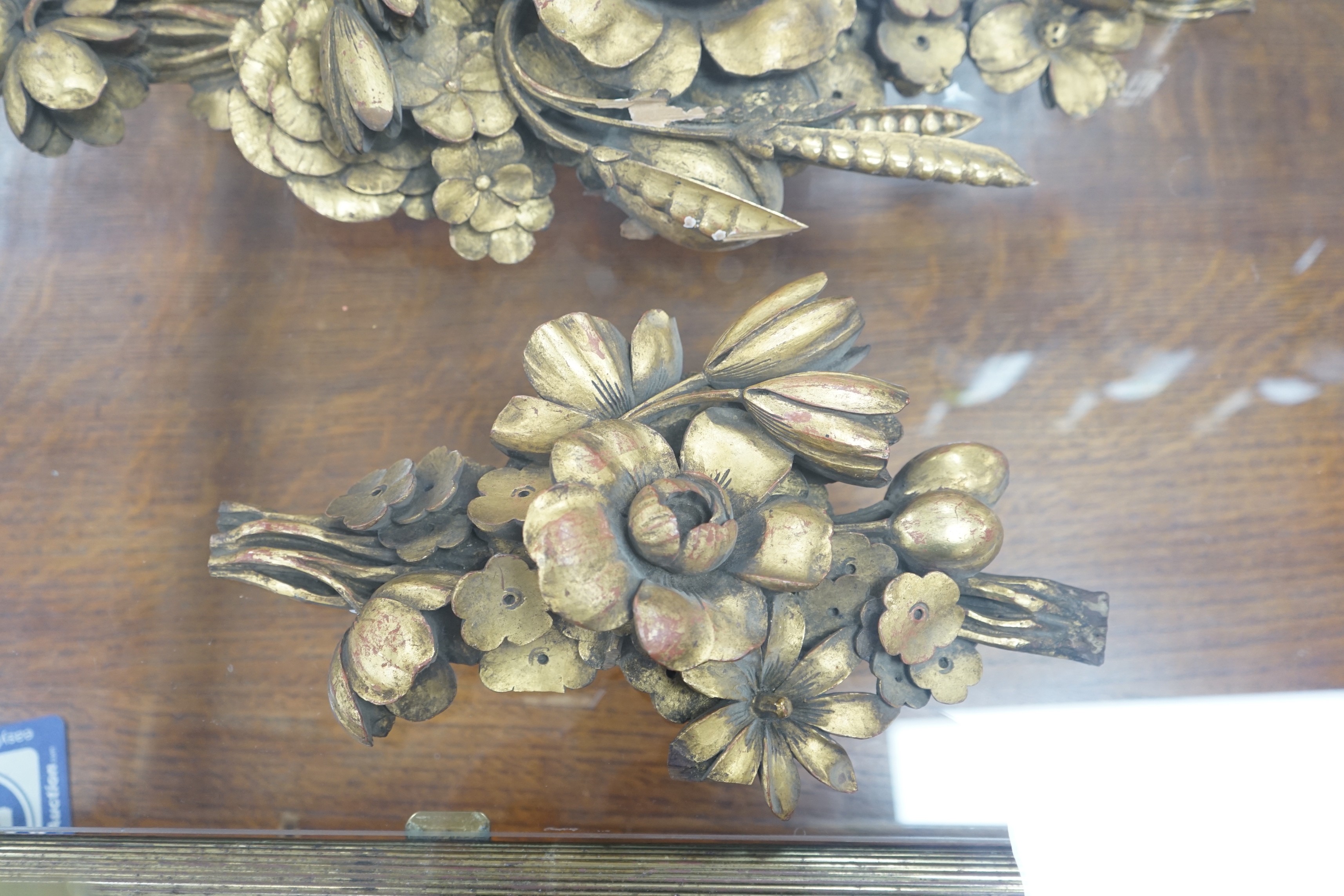 In the manner of Grinling Gibbons, two gilt carved motifs. Largest 59cm wide